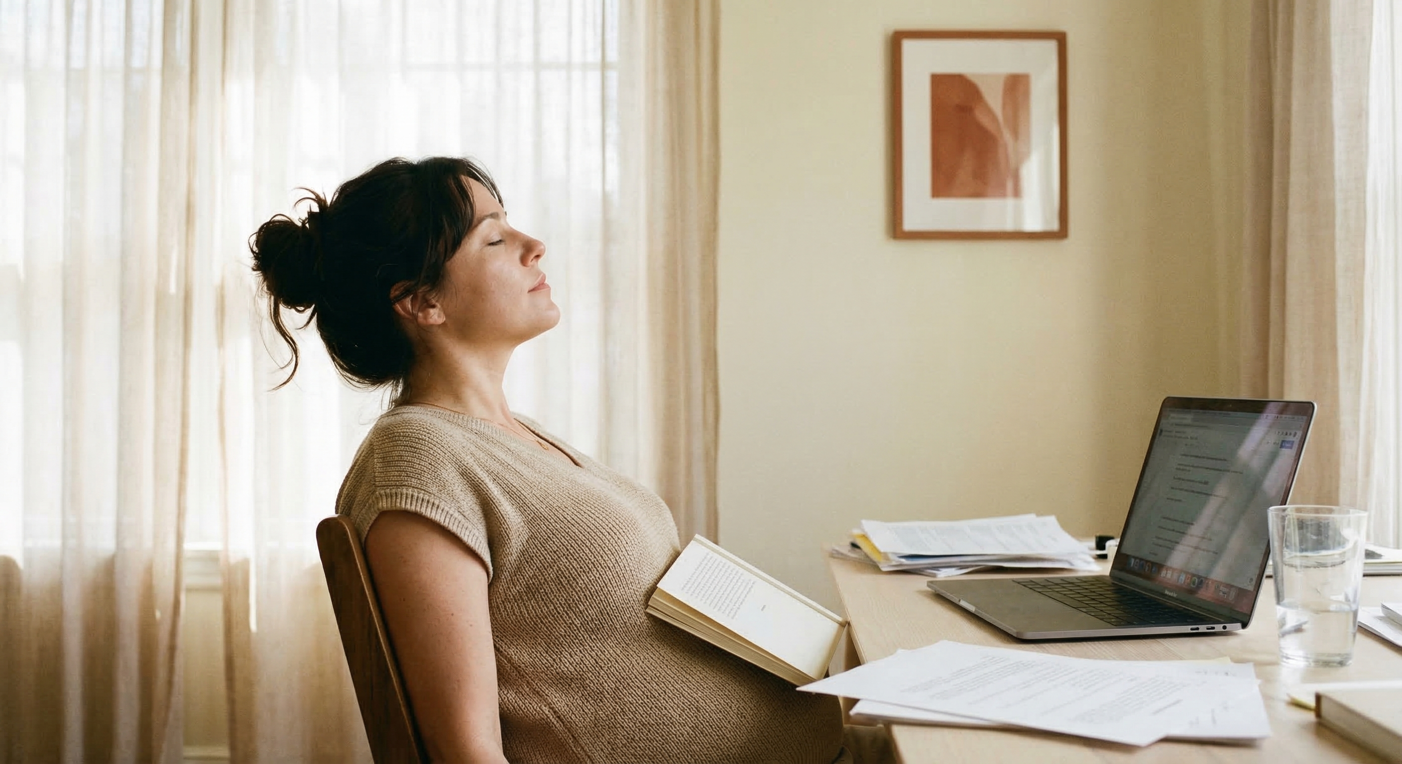 Una donna fa una pausa alla scrivania con un libro aperto